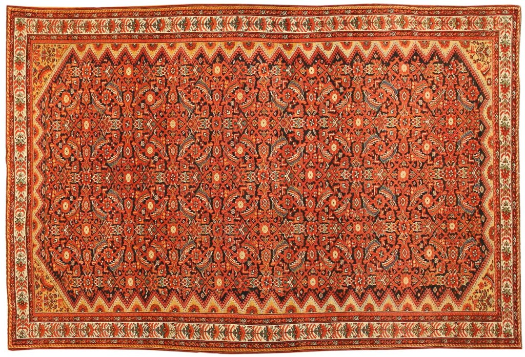 Sarouk tapijt, 191 x 132 cm. 'This dramatic carpet from the Farahan district features a characteristically dense Herati pattern in a Mina Khani-style arrangement that allows small amounts of the dark blue field to peek through. Multiple guardbands, taupe inner borders embellished with latchhook-pyramids and colorful border motifs set on neutral ground complete this richly-colored design.'