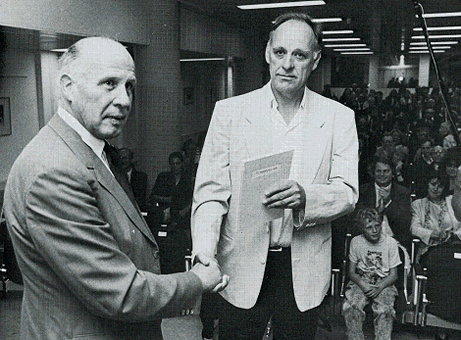 Hugo Brandt Corstius neemt op 3 juni 1988 in de aula van de Koninklijke Bibliotheek in 's-Gravenhage de geprivatiseerde P.C. Hooft-prijs in ontvangst. [Bron: DBNL]